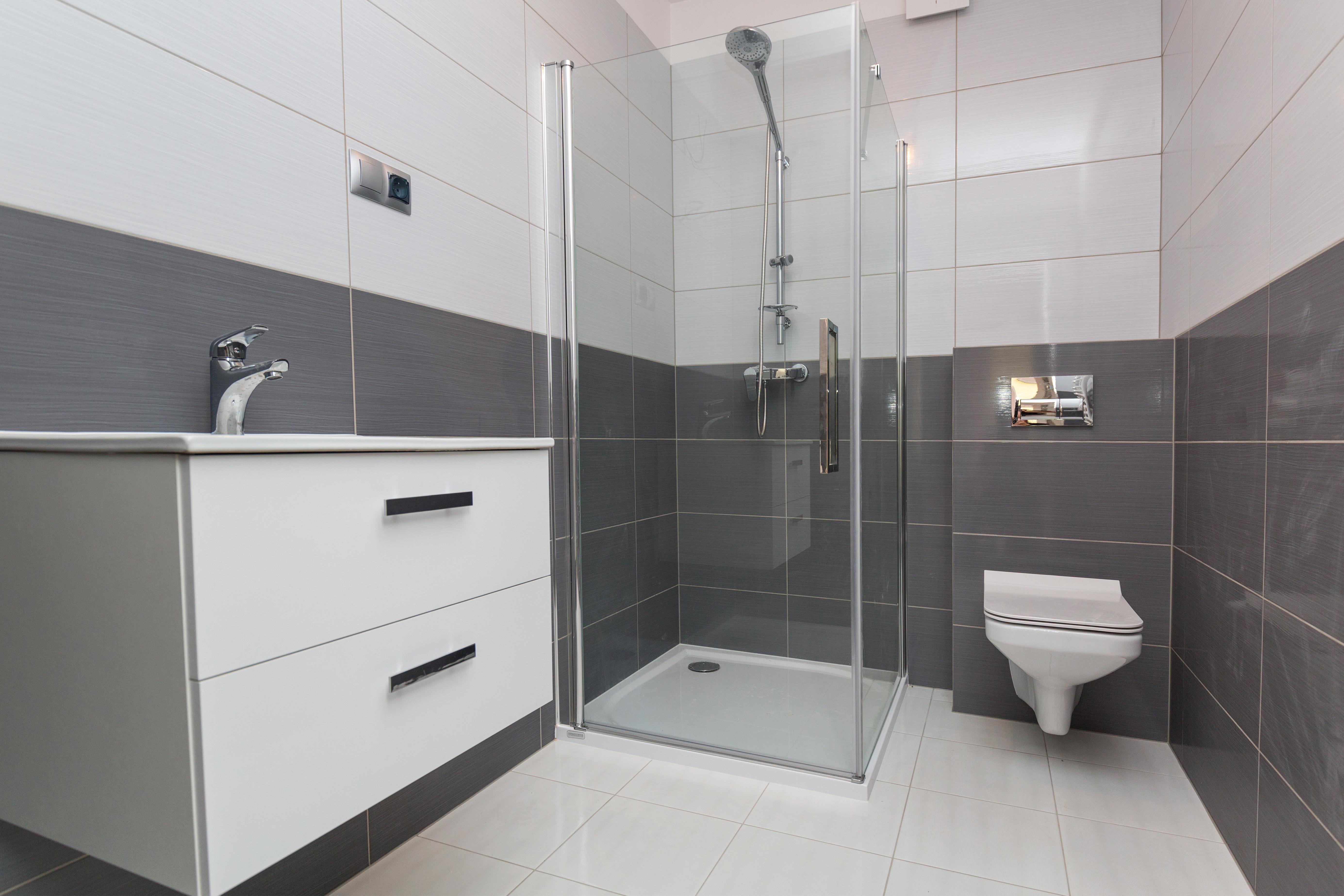 Neu gebautes Komplettbad in Berlin mit Eck-Glasdusche, Wand-WC und weißem Waschtisch