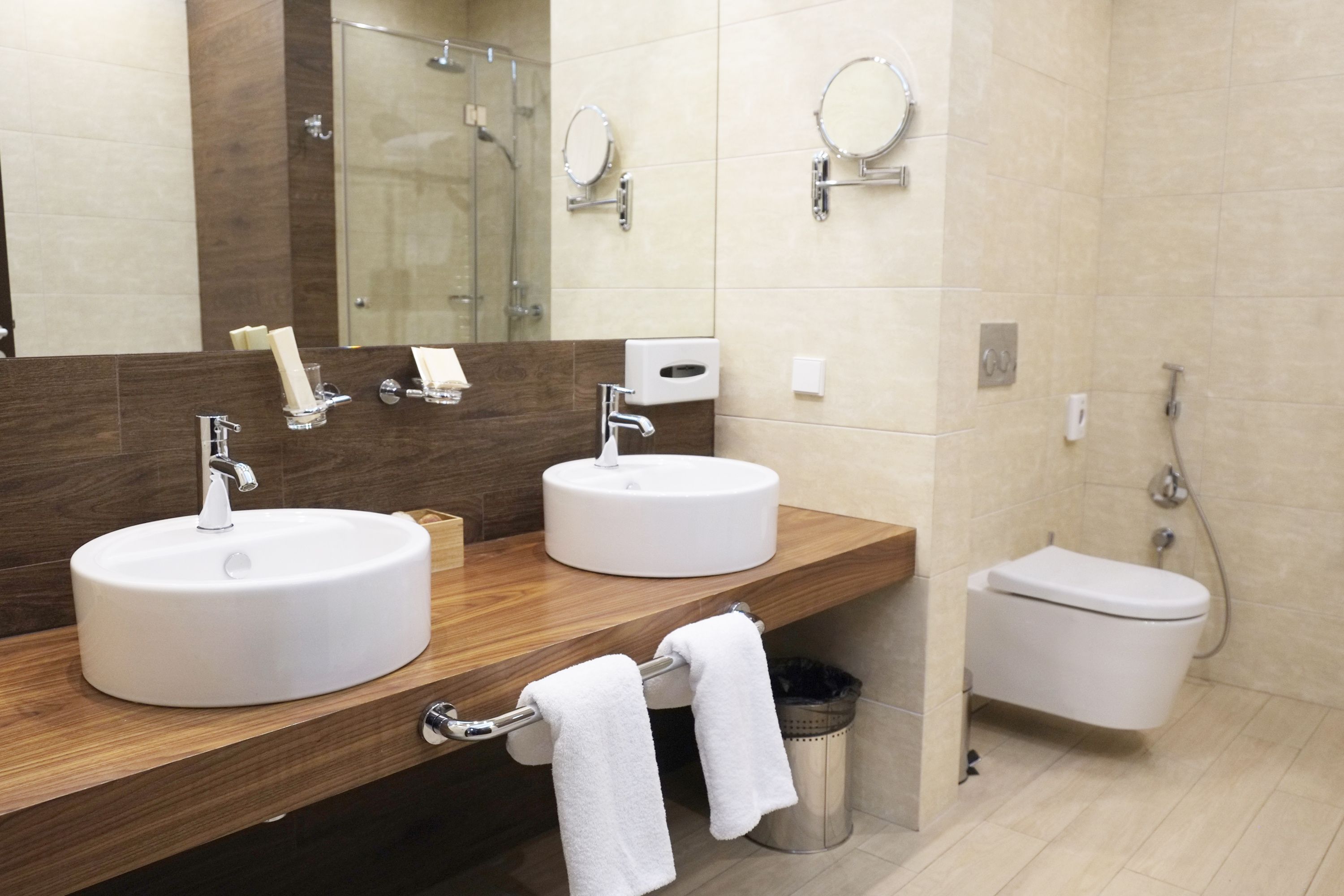 Hochwertige Komplettbadsanierung mit zwei runden Aufsatzwaschbecken auf Holzplatte und Wand-WC