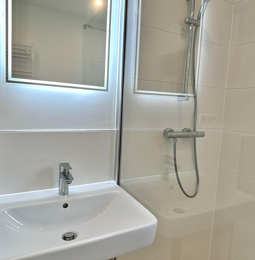 Fertig saniertes Badezimmer mit Waschtisch und Duschbereich in Berlin-Charlottenburg