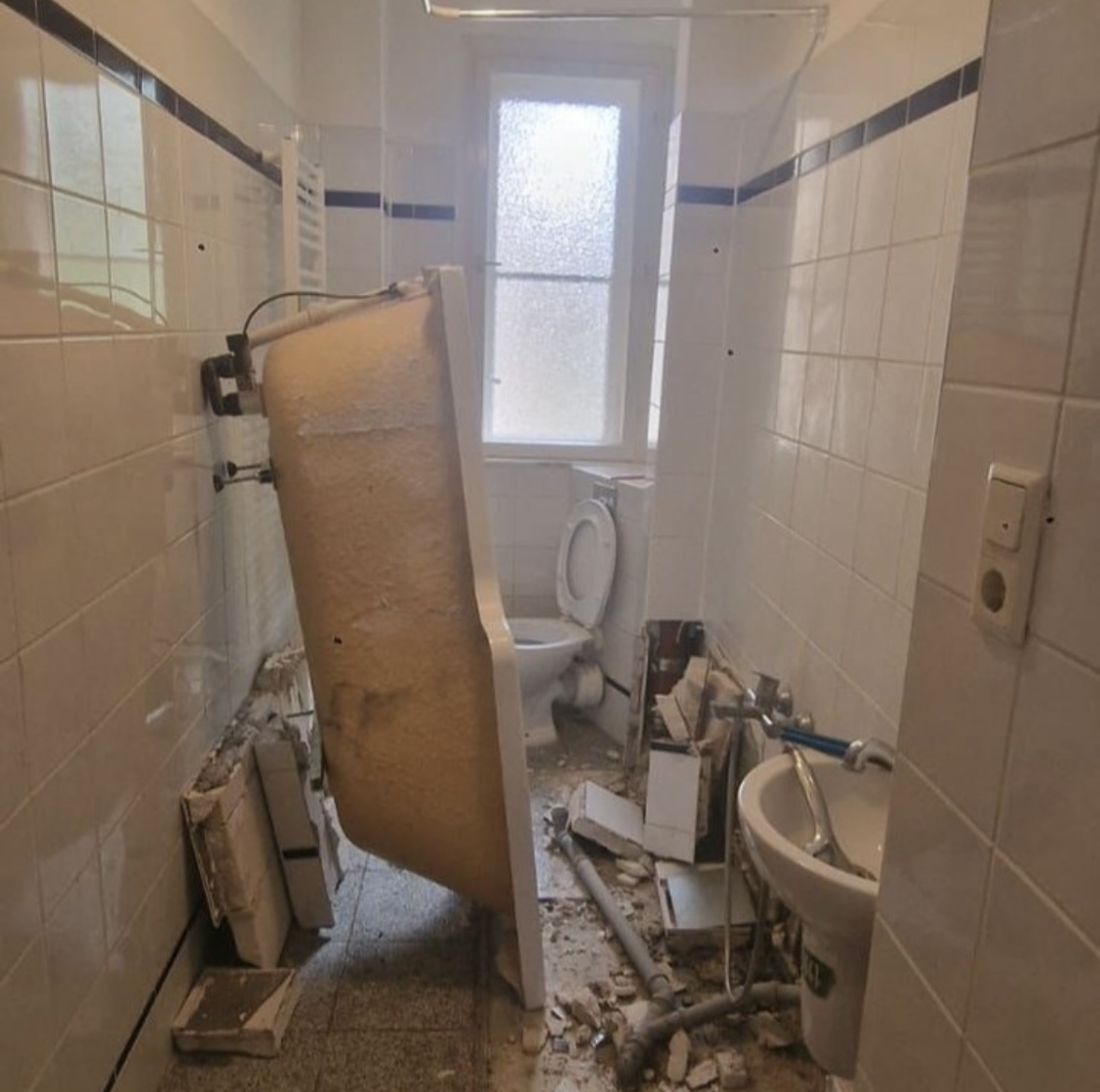 Rückbau eines alten Badezimmers mit demontierter Badewanne und Bauschutt in Berlin