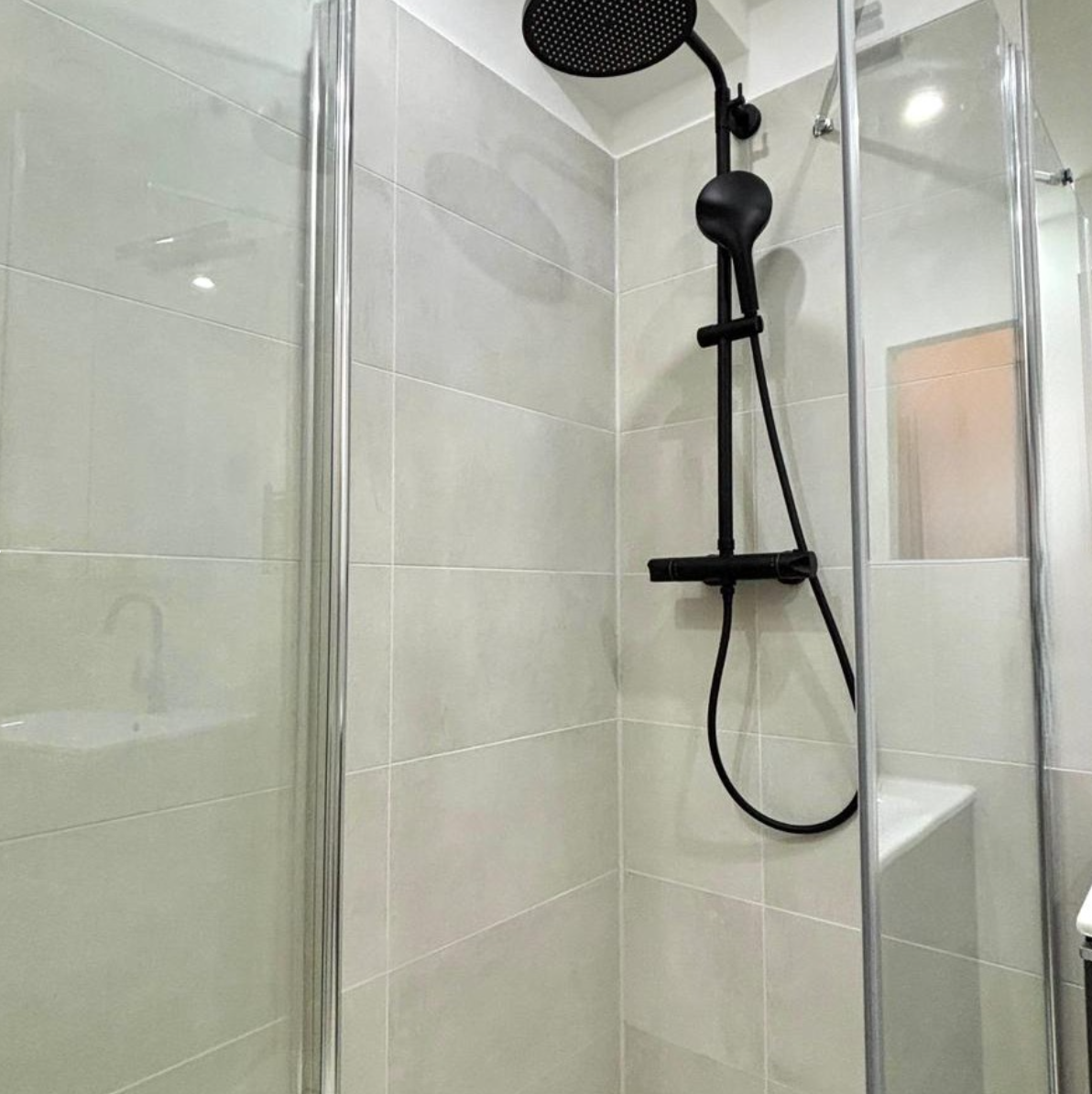 Bodengleiche Dusche mit schwarzer Armatur in einem barrierefrei sanierten Badezimmer in Berlin-Steglitz
