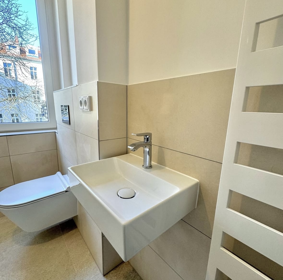Saniertes Badezimmer mit Fenster, WC und Waschtisch in Berlin-Wilmersdorf