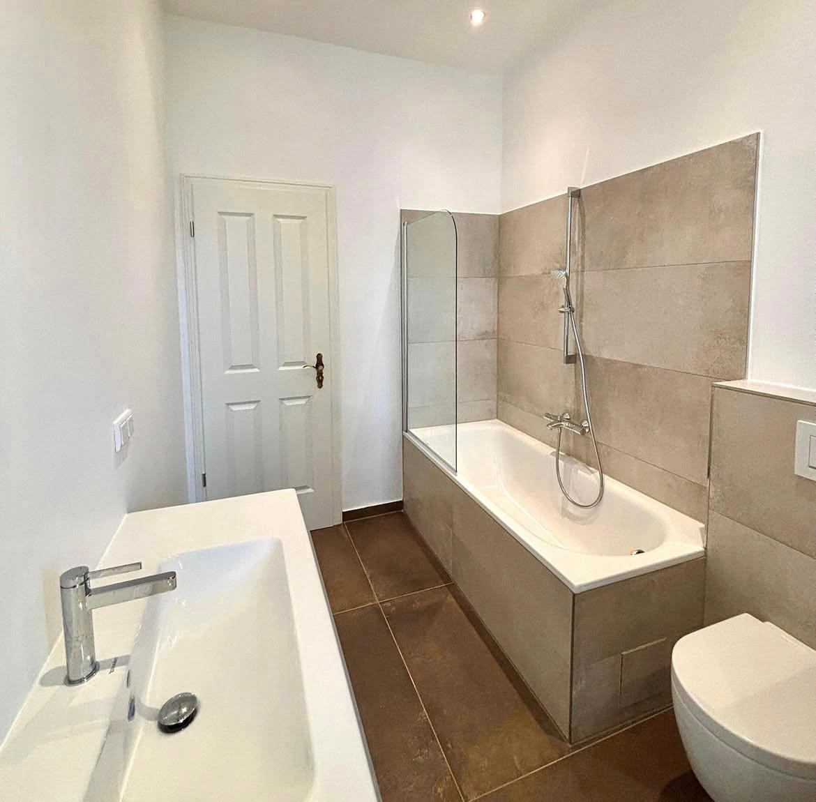 Saniertes Badezimmer mit Badewanne und großformatigen Fliesen in Berlin-Charlottenburg