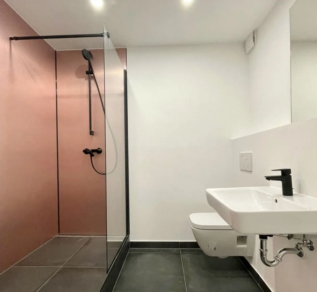 Fugenloses Bad in Berlin-Wilmersdorf mit Wandpaneelen in Kupferoptik, Waschtisch und Wand-WC
