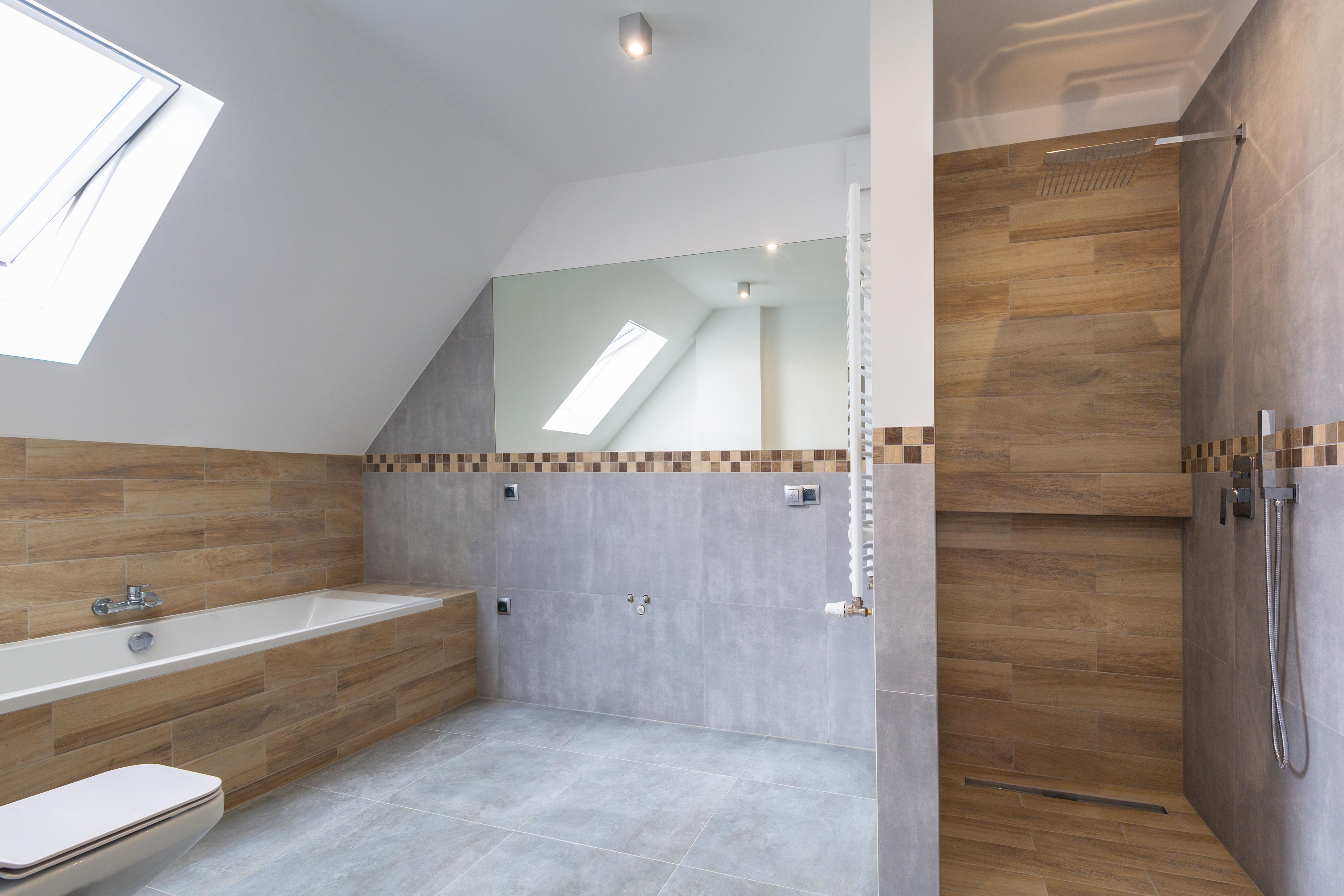 Sanitärarbeiten in Berlin – modernes Dachbad mit Holzoptik-Fliesen, Badewanne und Walk-in-Dusche