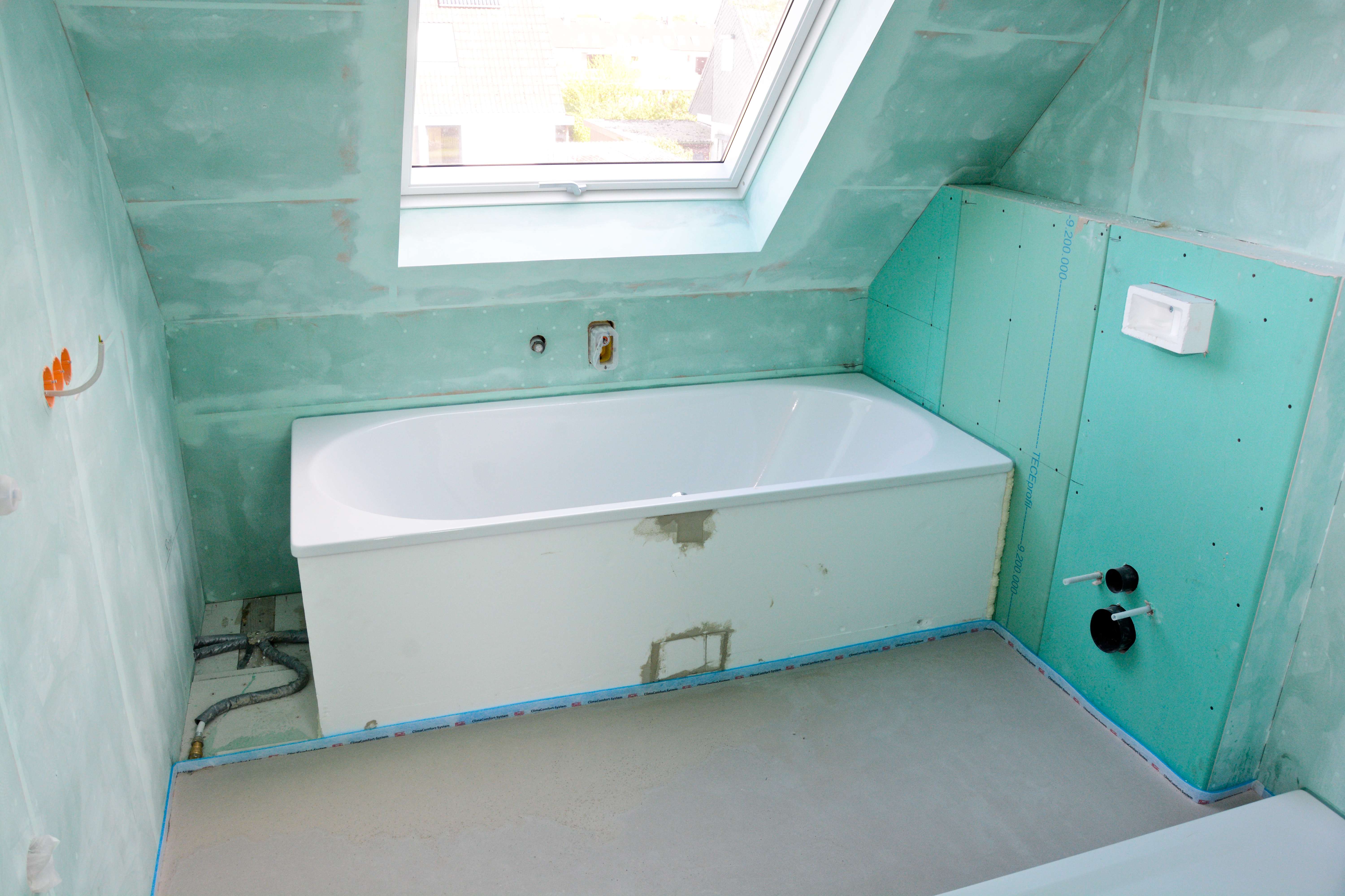 Sanitärinstallation während der Sanierung mit Feuchtraumplatten, eingebauter Wanne und Leitungen